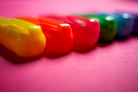 Close up of colorful markers on intense blurred pink background