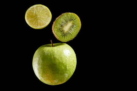 Green fresh organic fruits halves on black backgroundの写真素材