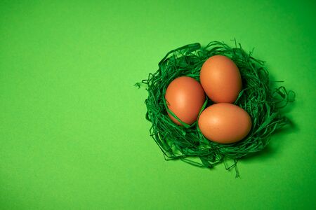 Easter eggs in a basket on green paper backgroundの写真素材