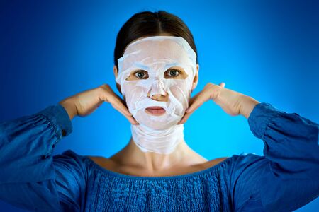 woman shows how to apply a beauty mask to your faceの写真素材