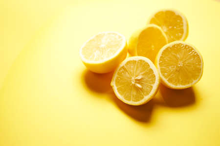 fresh lemons on a yellow minimalistic backgroundの写真素材