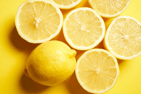 fresh lemons on a yellow minimalistic backgroundの写真素材