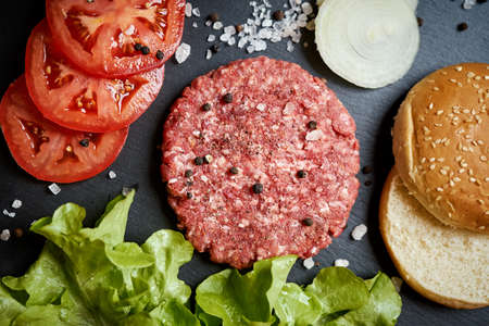fresh beef for burger on the table with lettuce onion and breadの写真素材