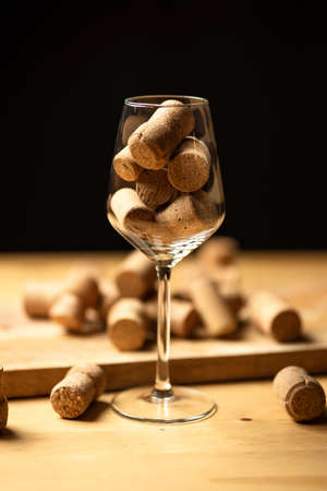 Bunch of wine corks in glass on wooden tableの写真素材