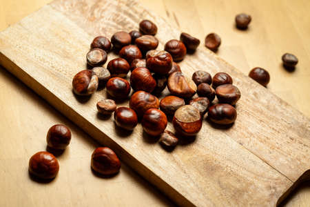 Fresh sweet edible chestnuts on wooden tableの写真素材