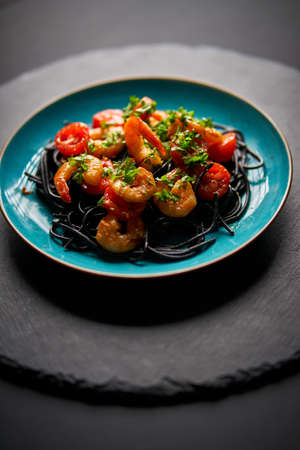 delicious fried shrimp with black spaghetti noodlesの写真素材