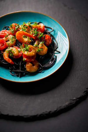 delicious fried shrimp with black spaghetti noodlesの写真素材