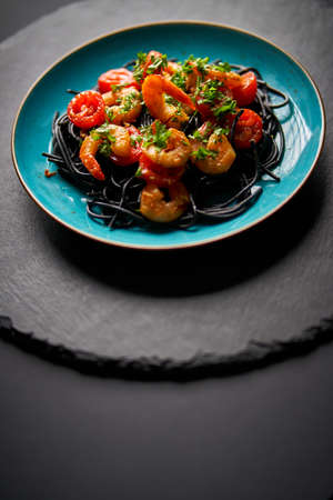 delicious fried shrimp with black spaghetti noodlesの写真素材