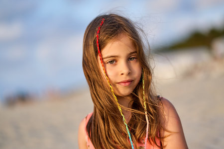 Portrait of a happy little girl on the beach during sunsetの写真素材