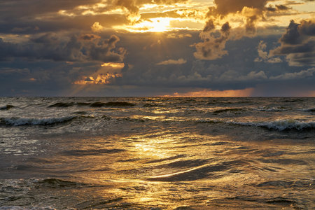 Epic dark sunset sky above the sea shore after the storm.の写真素材
