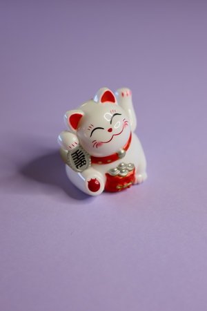An Adorable Cute Maneki Neko Figurine Set Against a Bright Purple Background for a Charming Display