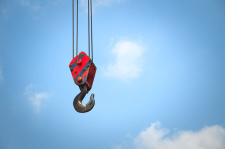 Crane hook on background is blue sky.