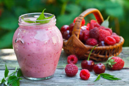 Yogurt smoothie with raspberries, strawberries and sour cherries dessert, healthy dieting conceptの写真素材