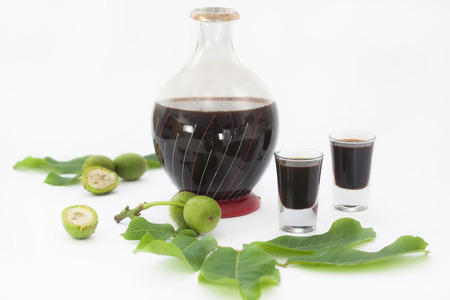 Bottle and two glasses with walnut liquor. Homemade wallnut liquer on white background.の写真素材