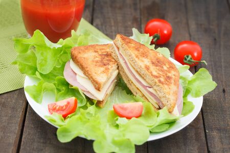 Club sandwiches on plate on wooden table. Salami, lettuce and cheese club sandwich on toasted bread.の写真素材