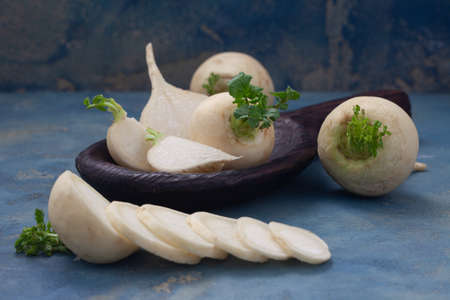 Raw white turnips on wooden board. Tasty fresh white  japanese radish. Healthy, vegetarian food.の写真素材