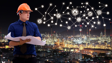 The engineer discussing a new project with large industry background with industrial instruments in...