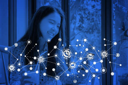 Close up of woman using mobile smart phone. Communication and technology icon overlay. Blue color background.の写真素材