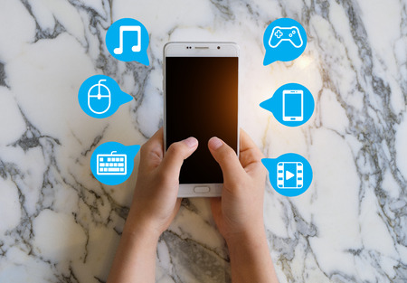 The smart phone on the human hands with social network icons.の写真素材