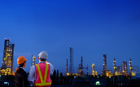 The engineers are standing on large industry background. The construction manager on the industry background.の写真素材