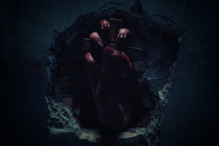 Horror Scene with Bloody Hand is holding a holy cross blood dirty.の写真素材