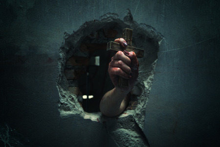 Horror Scene with Bloody Hand is holding a holy cross blood dirty.の写真素材