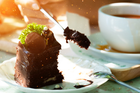 Eating chocolate cake in a coffee shop.の写真素材