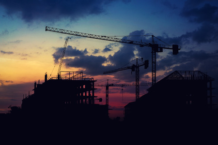 Silhouette construction crane and construction site at Thailand in sunset time.