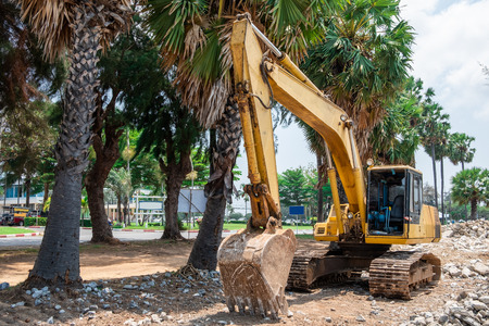 Yellow excavator is working on extend high way at construction site.