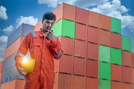 Engineer is working on Smart Phone at container yard. Industrial Container yard for Logistic Import Export business.の写真素材