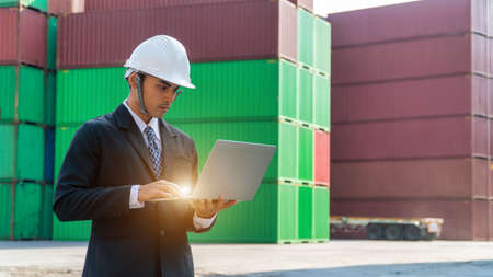 The network engineer is working on the laptop over the 5G network near by antenna tower. Business guy is sending the e-mail. The engineer is testing the wireless network.の写真素材