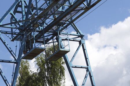 Metal construction of the crane, against the sky, in the warehouse, Russia