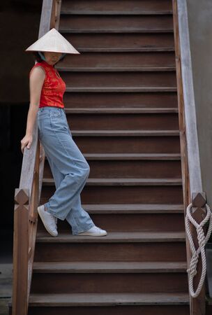 Asian woman standing on the old wooden stair in travel visiting ancient building の写真素材