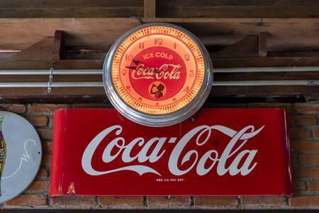 Bangkok, Thailand - June 19, 2019 : Vintage Coca Cola sign with antique clock on the brick wallのeditorial素材