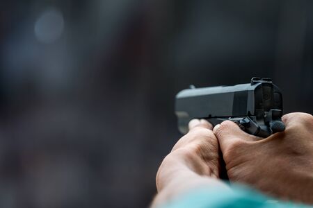 Man aiming gun pistol in shooting rangeの写真素材