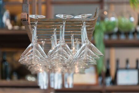 Empty glasses for wine above a bar rack in restaurantの写真素材