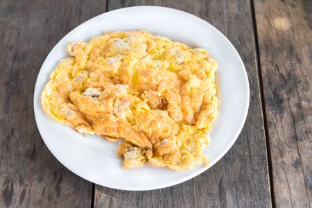Omelet or stir fried egg with Pork chops easy favorite delicious local Thai food for all meals every day on wooden tableの写真素材