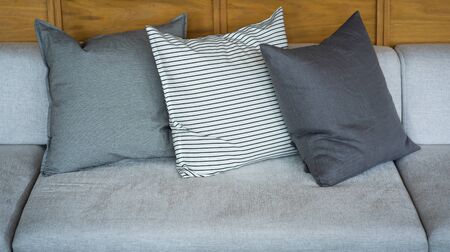 Modern colorful fabric pillows on gray cloth sofa design for office building interior or home and...