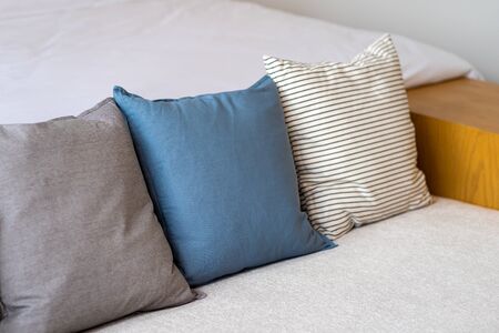 Modern brown blue and stripe fabric pillows on gray cloth sofa interior in living room decoration design building contemporaryの写真素材