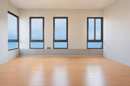 Empty room interior with windows overlooking the blue sky, Beautiful wooden floor and white wall...