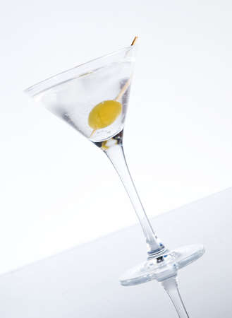 Martini with an olive on a light background