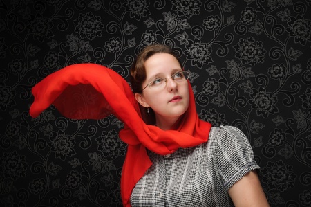 Charming woman over dark background with red shawl on the windの写真素材