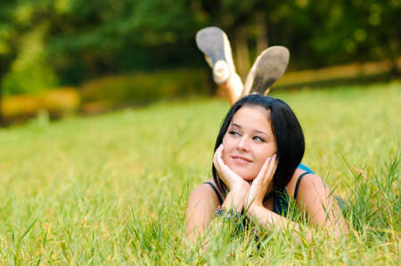 Pretty girl relaxing outdoor on green grassの写真素材
