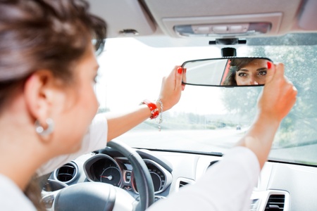Young woman corrected rear view mirrorの写真素材