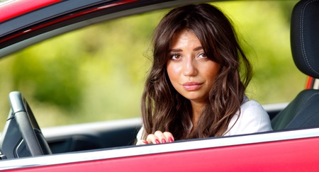 Young pretty scared woman in the car