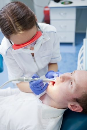 dentist at work on woman patient in officeの写真素材