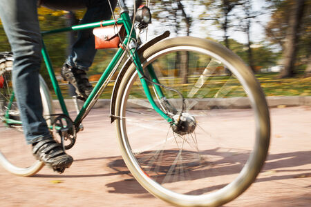 Close-up of young man riding bicycle in park
