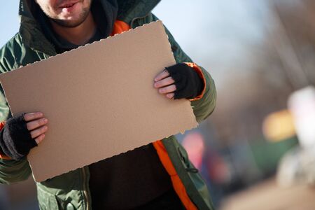 Homeless person with blanck cardboardの写真素材