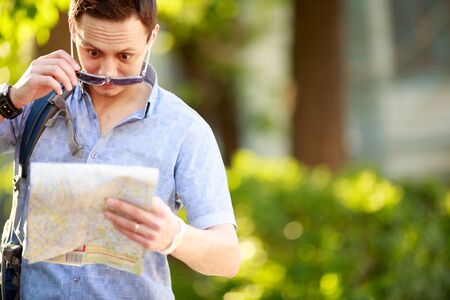 Young man with a map outdoors