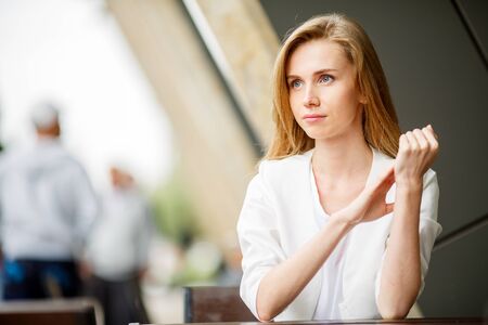 Portrait of a cute blonde woman sitting in a cafeの写真素材